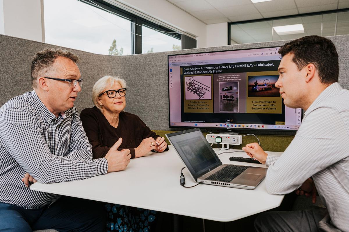 Everwell Associates consultants reviewing a manufacturer's quality compliance presentation with a client