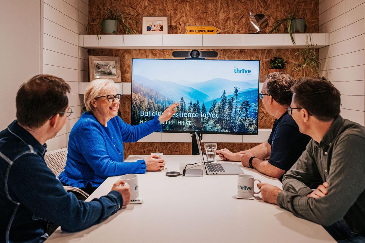 The Thrive Team coaching a client's senior leadership team in a meeting room